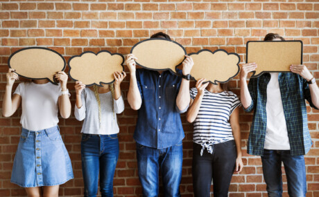 Junge Menschen halten sprechblasen vor ihre gesichter